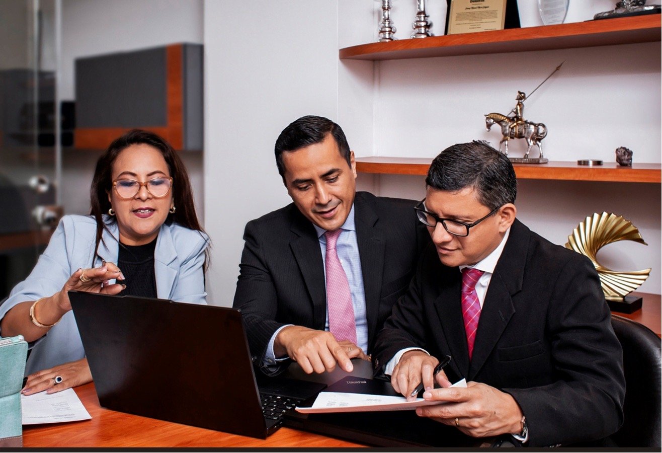 Profesionales de JM Consulting revisando documentación con un cliente
